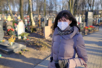 Woman in medical mask in a cemetery