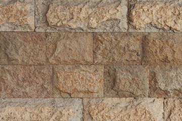 Wall made of yellow natural stone straight view 2