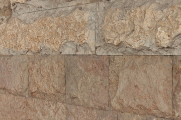 Wall made of yellow natural stone at an angle