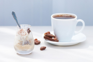 Cup of coffee, milk chocolate with nuts, ice cream with chocolate powder. Summer eat and drink for refreshment.