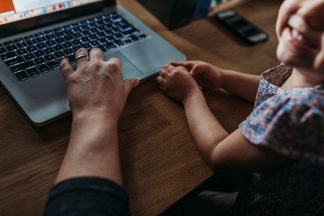 Close up view of young girl and father while he works from home