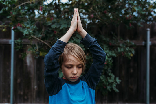 Portrait of boy doing yoga in backyard during isolation