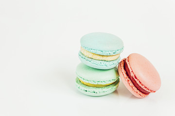 Sweet almond colorful pastel pink blue green macaron or macaroon dessert cake isolated on white background. French sweet cookie. Minimal food bakery concept Copy space