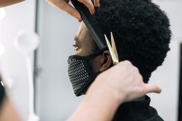 black guy in a hair salon with a coronavirus mask