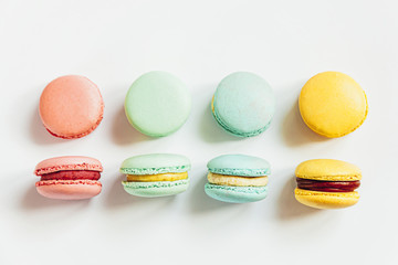Sweet almond colorful pastel pink blue yellow green macaron or macaroon dessert cake isolated on white background. French sweet cookie. Minimal food bakery concept. Flat lay top view, copy space