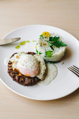 poached egg on steak with rice garnish