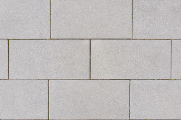Close up small tiny stone pebble in concrete block tile with running bond pattern floor texture...