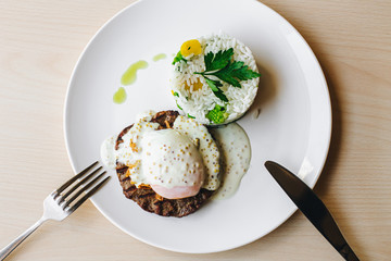 poached egg on steak with rice garnish