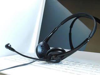 online communication: headphone set over laptop keyboard.