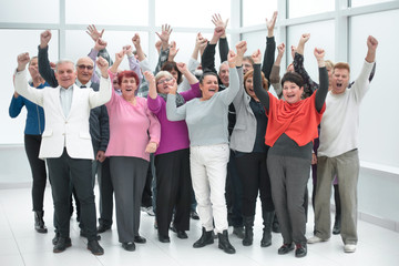 Obraz premium Happy group of people raising their hands to rejoice of victory