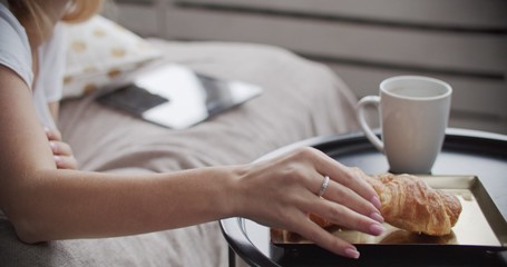 Girl lying on bed having breakfast