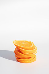 Close up cut slice of orange fruits on white background with hard light.  Summer and freshness concept. Citrus with vitamin c for health and diet.