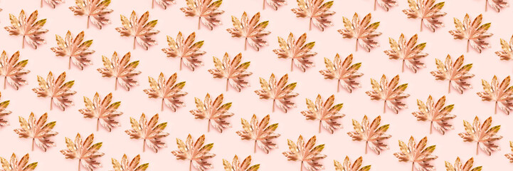 Beautiful Leaf Pattern. Leaves are painted in golden and copper metallic paint on pink background. Autumn minimalism. Isometric flat lay, banner size