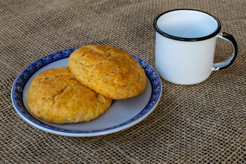 corn cake on plate with blue border and white mug on jute towel