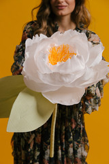 Giant paper flower held by a smiling girl