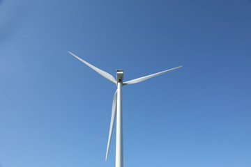 Windmill for electric power production, France. Blue sky