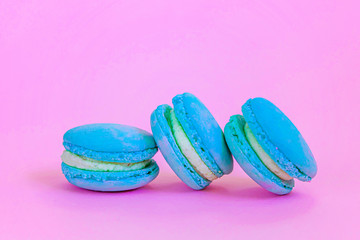Sweet almond colorful unicorn blue macaron or macaroon dessert cake isolated on trendy pink pastel background. French sweet cookie. Minimal food bakery concept Copy space