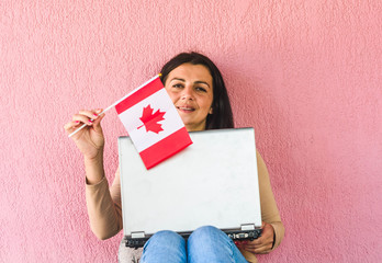 woman with laptop computer and flag of  Canada