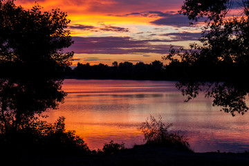 Beautiful colourful morning sky by the river. Orange and violet sky reflection in the water, Dnipro, Ukraine