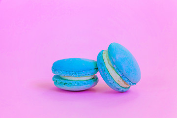Sweet almond colorful unicorn blue macaron or macaroon dessert cake isolated on trendy pink pastel background. French sweet cookie. Minimal food bakery concept Copy space