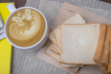 Top view Homemade slide bread with hot coffee cup on the wooden.