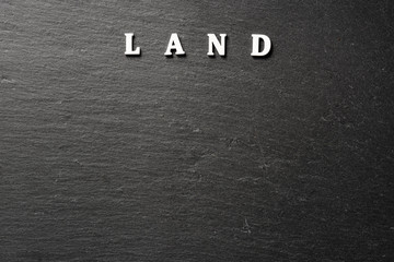 Land word on black stone