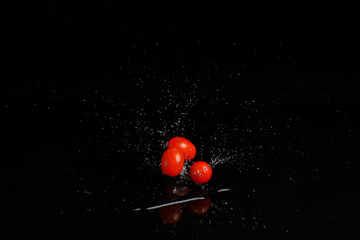 Fresh cherry tomatoes on black background