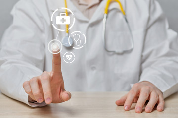 The doctor abstractly clicks on the display with the choice of the necessary help.