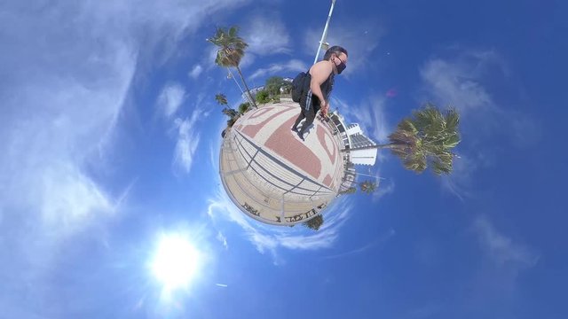 chico con tirantas andando por el paseo mar&iacute;timo en un mini mundo