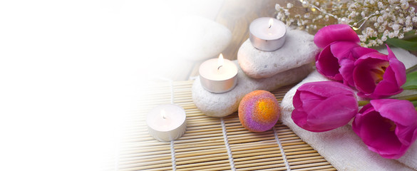 Obraz na płótnie Canvas Mock up romantic spa with bath bomb, tulips, candles and pebbles on wooden background. Resort concept for Valentines day, Mothers day or wedding greeting card.