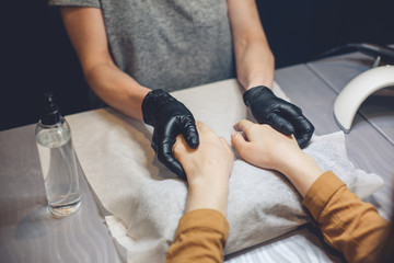 Beautician applying cream on client hands. Beauty salon. Hands Massage. Manicure at salon. Spa Manicure concept. Female hands with delicate manicure and moisturizing cream. Soft skin. Hand, beauty