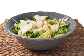 Salad - Salad with cheese, ham, nuts and fruit particles. Wicker on white background

