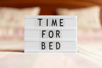 Lightbox with text: time for bed, on the bed.