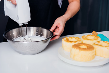 Woman beat dough mixer by machine in bowl at her kitchen