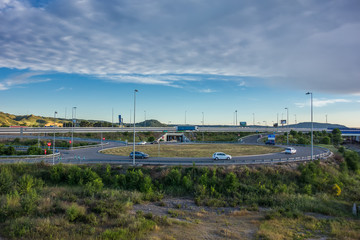Obraz premium View of a roundabout accessing the A-2 road outside Alcalá de Henares, in the afternoon with little traffic.