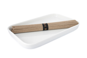 Soba noodles, buckwheat noodles on white plate, on white background
