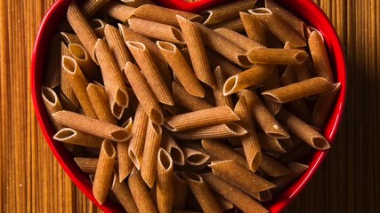 Top view of uncooked pasta integral on a wooden background