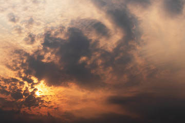 Fototapeta premium Orange light shining through the overcast clouds.