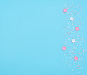 Pink and white flowers made of foamiran with star shaped confetti on blue background. Mother day, Valentine day, Wedding, Birthday concept. Greeting or invitation card. Flat lay with copy space.