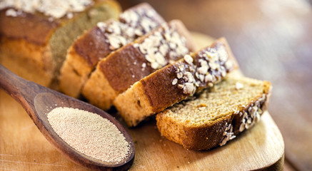 Sliced ​​vegan bread, gluten-free and without animal products. Vegetarian bread with oats, banana flavor, with wooden spoon with dry biological yeast.
