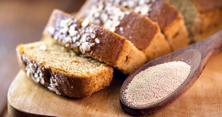 Sliced ​​vegan bread, gluten-free and without animal products. Vegetarian bread with oats, banana flavor, with wooden spoon with dry biological yeast.