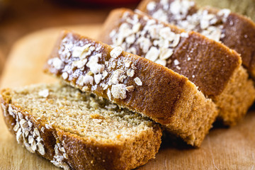 Sliced ​​vegan bread, gluten-free and without animal products. Vegetarian bread with oatmeal, banana flavor, on a rustic white table, sliced ​​and ready to serve.