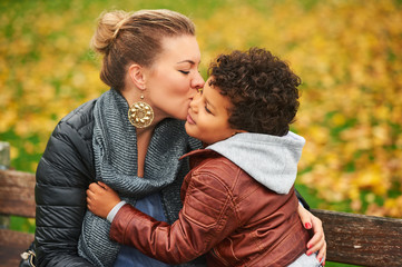 Fototapeta premium Happy young mother holding sweet toddler boy family having fun together outside on a nice autumn day