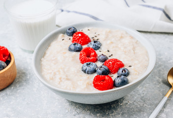 Breakfast oatmeal porridge with fresh berries and almond milk. Healthy vegan food concept. Top view. Copy space. Flat lay