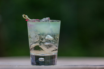 Lemonade with ice. A fresh summer non alcoholic fruit and berry cocktail. Photo with flowers