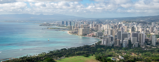 Wide panoramic shot of coastal city with azure waters, shot at Diamond Head Lookout near Honolulu,...