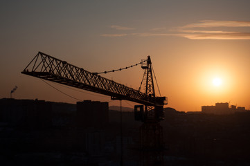 Fototapeta na wymiar Silhouette crane in building construction site on sunset background