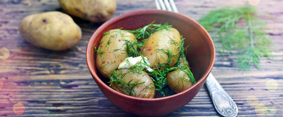 Young boiled potatoes with butter and dill on a wooden background of an old tree. country style. Organic food. copy space