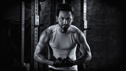 Fototapeta na wymiar sport portrait of caucasian athletics strong bodybuilder man posing show his muscle in gym in dark tone black and white