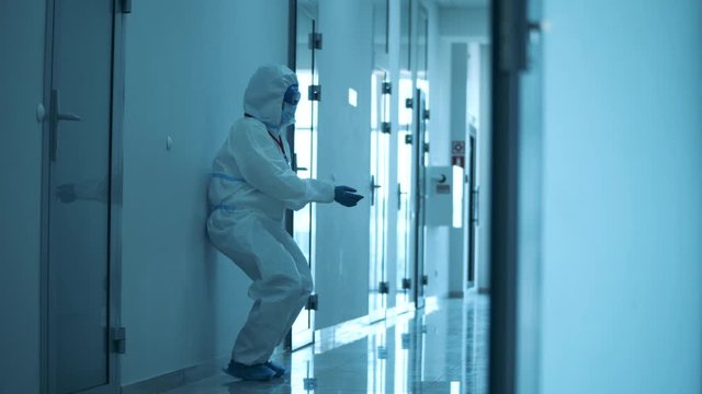 Female paramedic walks along the hall and sits down on the floor